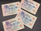 three old german bank notes on a black surface