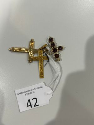 une croix en or ornée de grenats, à laquelle est attachée une étiquette de prix