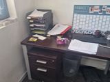 a desk with a computer and a printer in the corner of the room