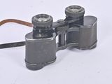 an old pair of binoculars sitting on top of a white surface