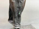 bronze statue of a woman holding a bird on a base