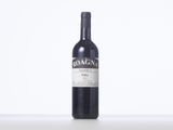 a bottle of red wine sitting on top of a white table