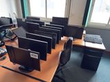 many computer screens on the desk in the room