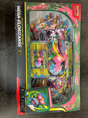the box contains a variety of pokemon cards, including a pink and green pokemon figure
