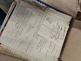 a box full of papers sitting on top of a bed