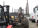 a tractor that is parked in a lot with other trucks