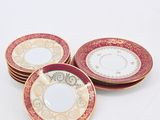 four plates with gold and red designs are stacked on top of each other