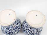 two blue and white vases sitting on a white surface