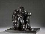 statue d'un homme assis sur un socle, la tête entre les mains