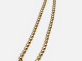 a close up of a pearl necklace with a gold clasp on a white background