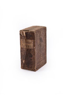 an old book sitting on top of a white surface
