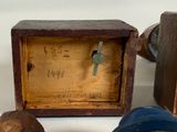 a small wooden box with a clock on top of it