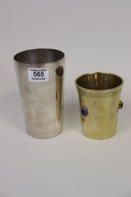 Deux tasses en argent sont posées l'une à côté de l'autre sur une surface blanche