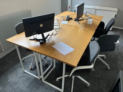 a desk with two monitors and a keyboard on it