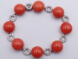 an orange bracelet with crystal beads and a silver clasp