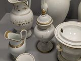 a lot of white and gold china on a table