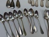 many spoons and forks laid out on the table