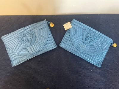 two blue purses sitting on top of a blue table