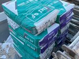many bags of cement sitting on the back of a truck