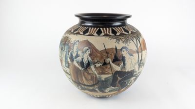 a vase with a painting on it sitting on a table