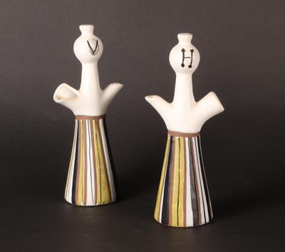 paire de figurines en céramique représentant un homme et une femme sur fond noir