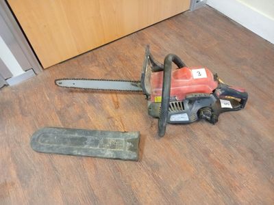 a chainsaw on the floor next to a piece of wood