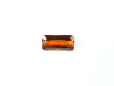 une image représentant un morceau de verre orange posé sur une surface blanche