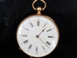une montre de poche en or avec des chiffres romains sur le cadran
