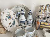 many pieces of pottery sitting on a white table