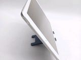 a tablet computer sitting on a stand on a white surface