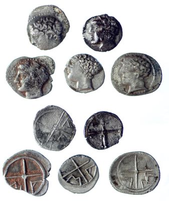six ancient roman coins are shown in a row on a white surface