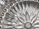 a silver plate that has a flower design on it