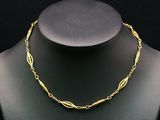 un collier en or autour du cou d'un mannequin, sur fond noir