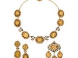 une photo d'un ensemble composé d'un collier et de boucles d'oreilles sertis de pierres jaunes