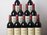 six bouteilles de vin rouge sont posées sur une table devant un mur blanc