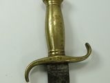 a gold colored sword with a black handle on a white surface