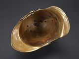 a close up of a brass helmet on a black background