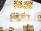 many gold cuff watches and cuff bracelets on a table