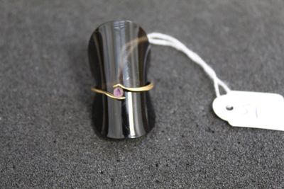 une bague posée sur un objet noir muni d'une étiquette de prix