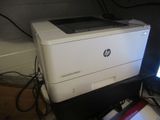 a white printer sitting on top of a desk next to a computer monitor
