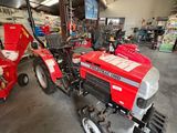 un tracteur rouge garé à l'intérieur d'un bâtiment