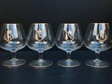 trois verres à vin vides, aux bords dorés, sont posés sur une table