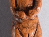 une figurine en bois représentant un homme assis sur une table