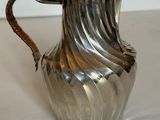une cafetière en argent posée sur une table blanche
