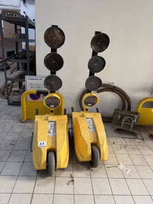 two yellow traffic lights sitting next to each other on the floor