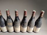 six bottles of wine are lined up in a row on a table