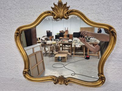 un miroir accroché au mur, sur lequel une personne est en train de travailler