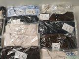 a lot of men ' s shirts in plastic bags on a table