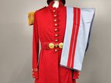 a red uniform on a mannequin with a white hat and a blue scarf