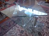 a glass table with a bowl on it in the middle of a living room